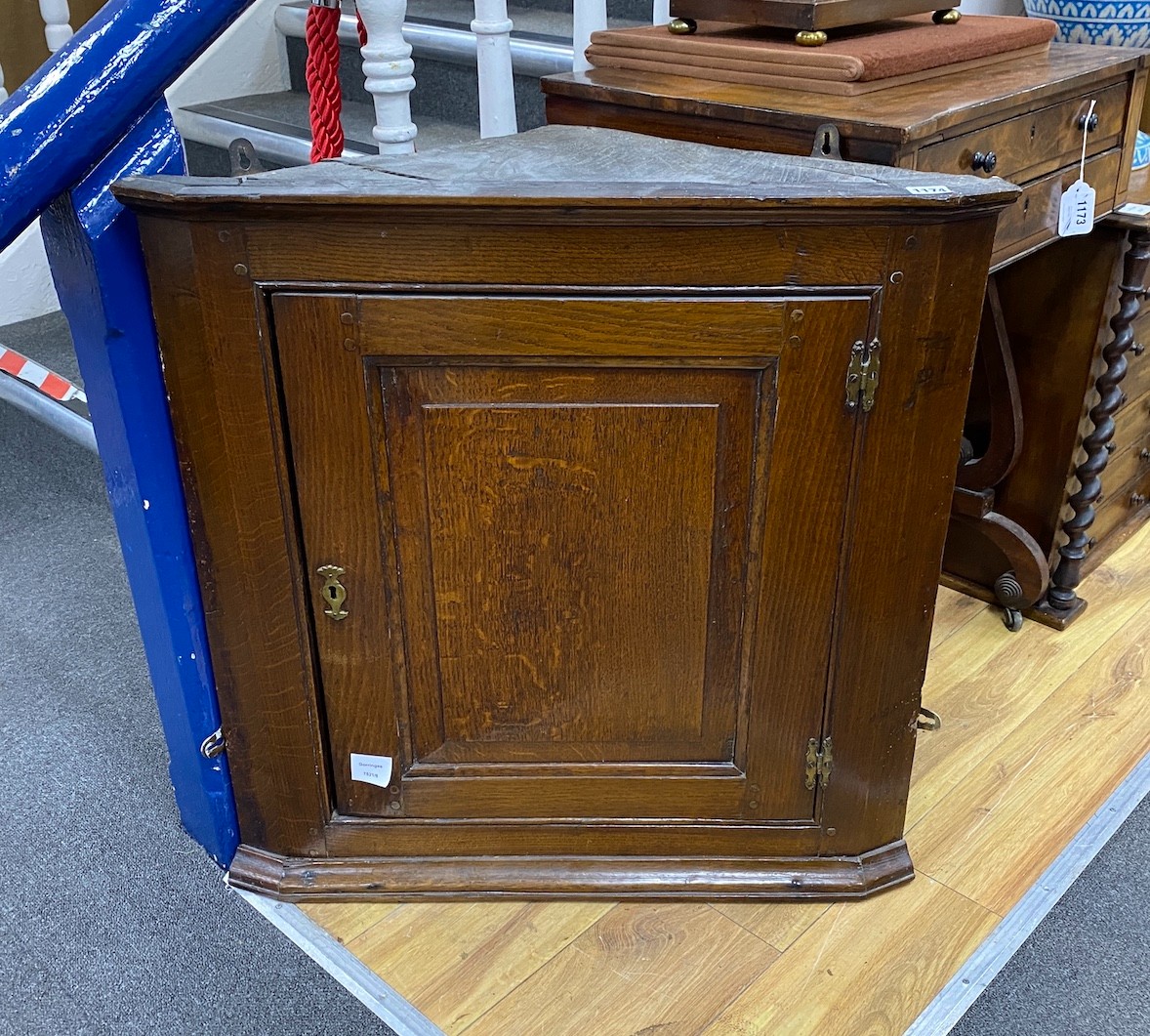 A small George III oak wall hanging corner cupboard, with hinged panelled door and shelved interior, width 70cm, depth 33cm, height 71cm